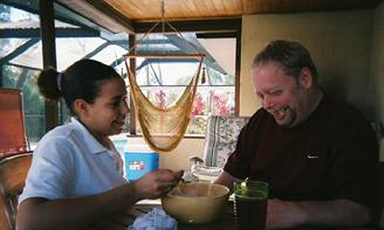 A home care companion helps Adam with his meal